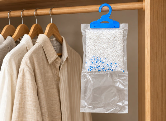 Sac absorbeur transparent à crochet bleu suspendu près de chemises, avec granulés blancs et bleus