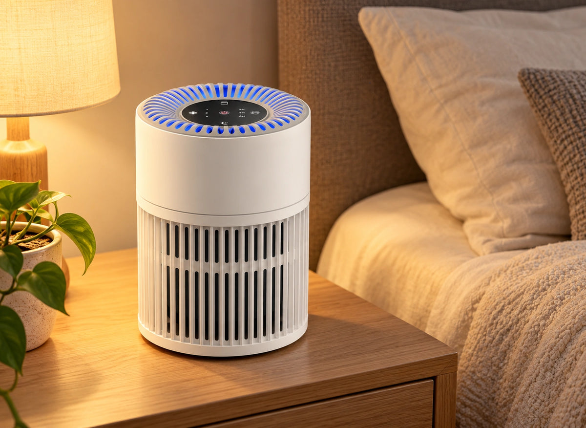 Purificateur compact blanc avec éclairage bleu, posé sur une table de chevet près d’un lit
